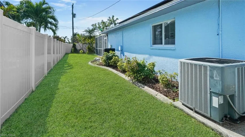 View of eastern side yard featuring cooling unit, pool heater, and irrigation system.