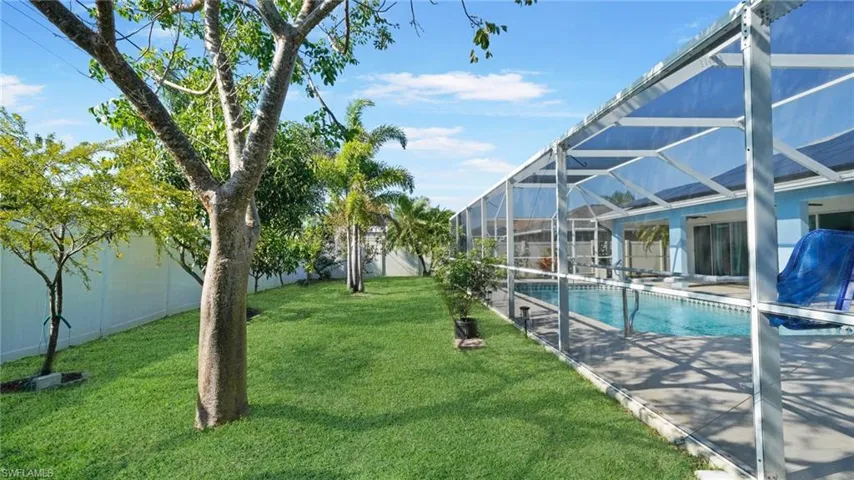 Fenced back yard showing pool enclosure