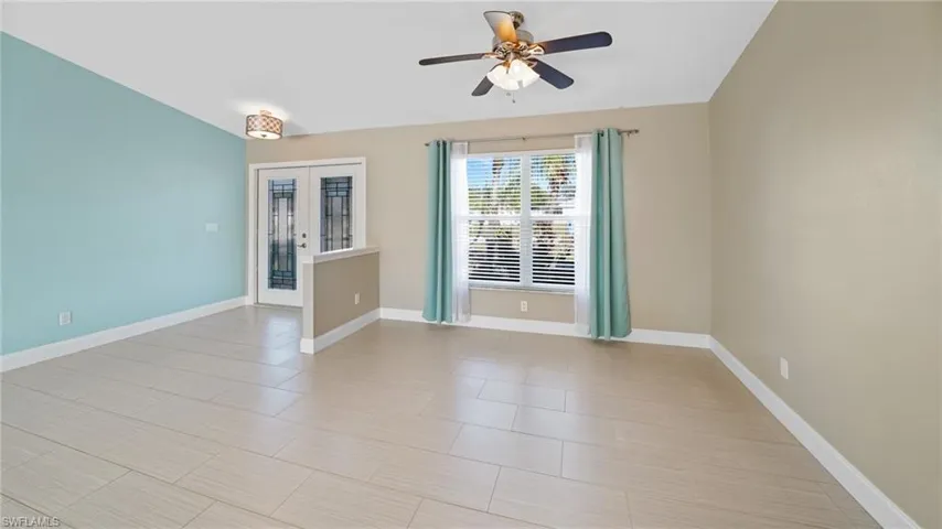 Dining area with ceiling fan and double-door entry.