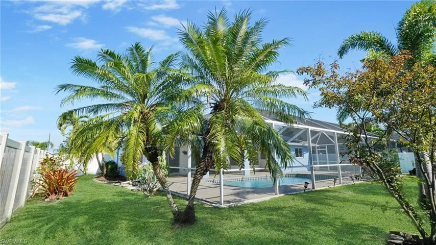 Pool from outside enclosure showing fence and tropical plantings