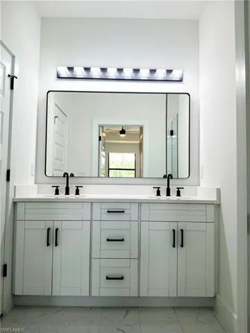 Bathroom with tile patterned floors and dual bowl vanity