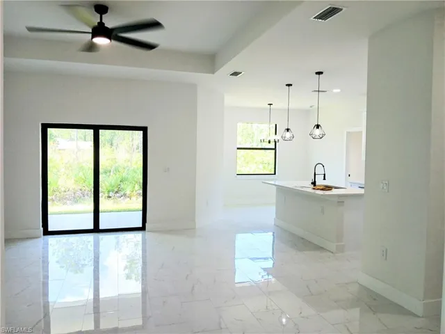 Unfurnished living room featuring plenty of natural light, sink, and ceiling fan