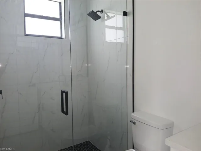 Bathroom with a shower with door and toilet
