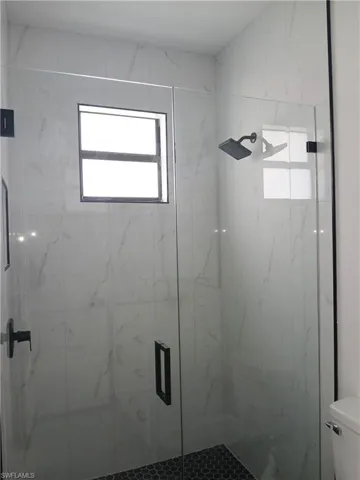 Bathroom featuring an enclosed shower and toilet