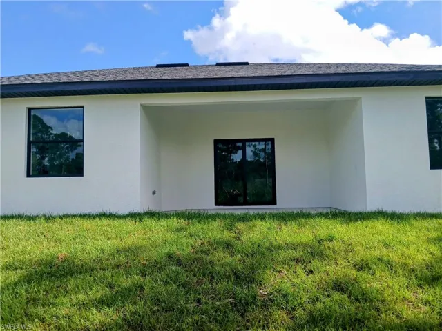 Back of house with a yard