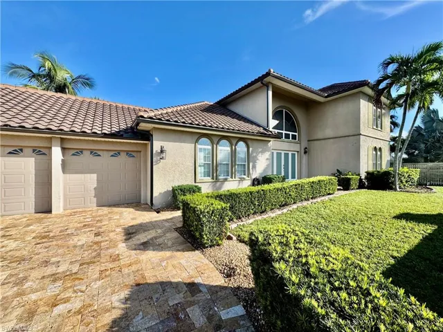 Mediterranean / spanish house featuring an attached garage, stucco siding, driveway, and a tiled roof