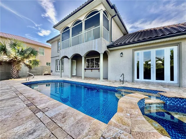 Rear view of house featuring stucco siding, a patio area, an outdoor pool, and a tiled roof