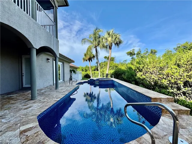 View of swimming pool with a patio and a pool with connected hot tub