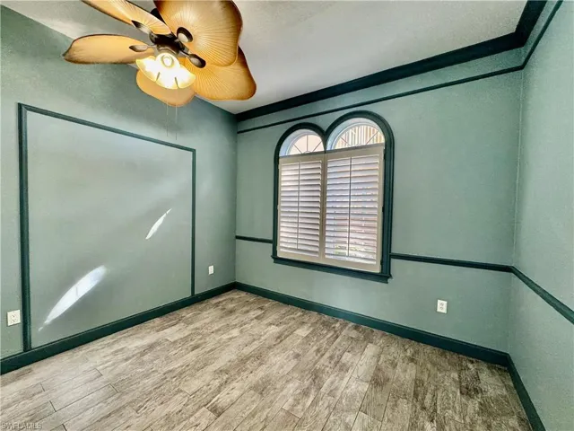 Spare room with wood finished floors and a ceiling fan
