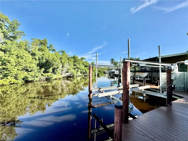 Dock area featuring boat lift and a water view