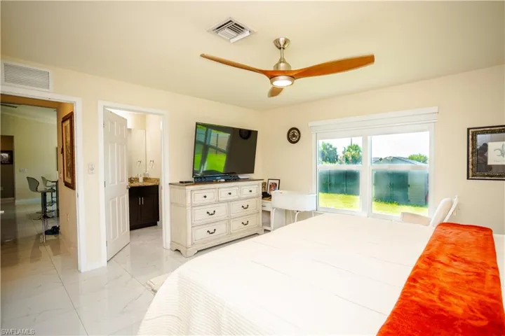 Spacious room featuring white tile flooring and a ceiling fan with integrated lighting
