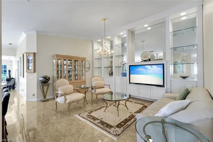 Recessed lighting illuminates extensive custom built-in shelving with mirrored back panels and glass shelves