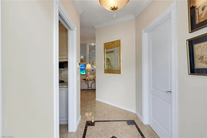 Tiled flooring with dark accent border, crown molding, and a built-in ceiling light fixture