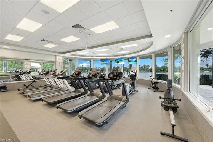 Curved window walls, recessed lighting, drop ceiling, and carpeted flooring