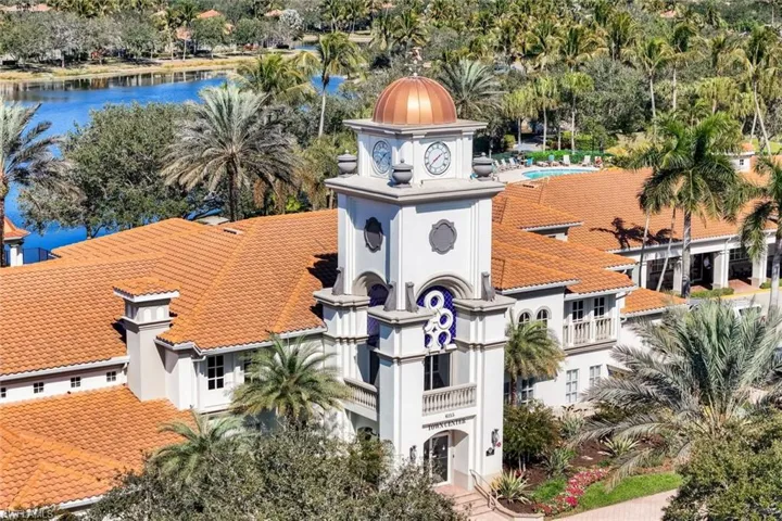 Building with a prominent clock tower, copper-domed cupola, and tile roof