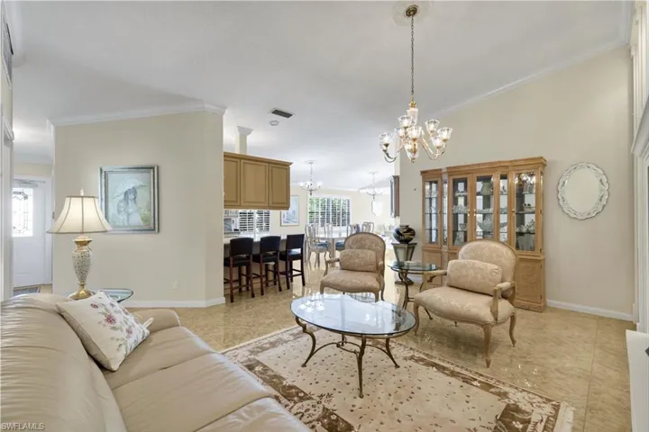 Vaulted ceilings, tiled flooring, built-in cabinetry, and a chandelier with a ceiling medallion