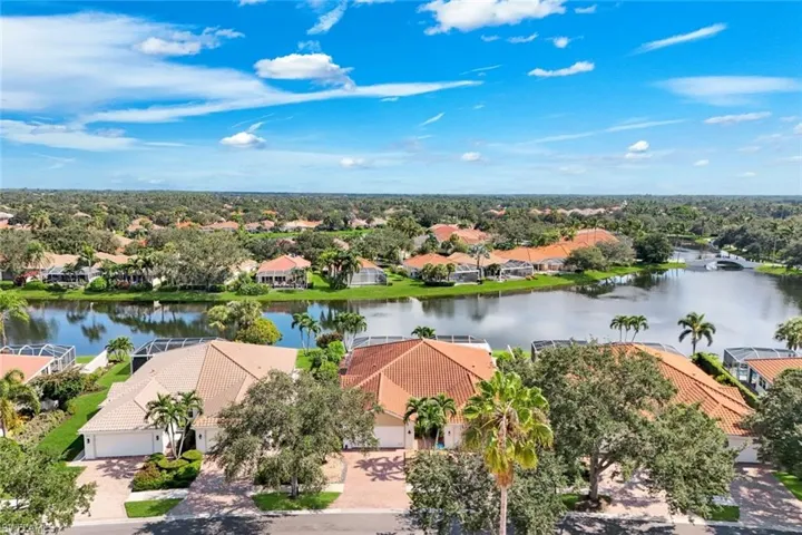Aerial perspective of a neighborhood featuring a large central pond