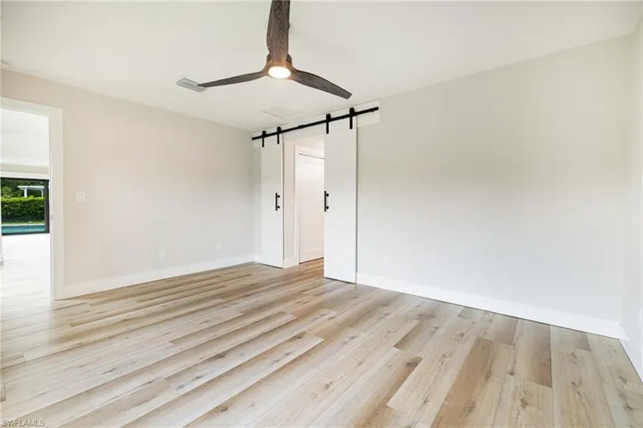 primary bedroom with barn door leading to primary bath