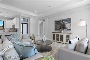 Tiled living room featuring a tray ceiling