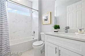 Full bathroom featuring shower / bathtub combination with curtain, vanity, and toilet