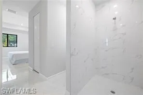 Bathroom featuring tiled shower and tile flooring