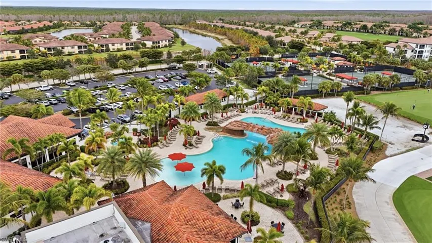 Aerial view of residential area with a nearby body of water and a pool