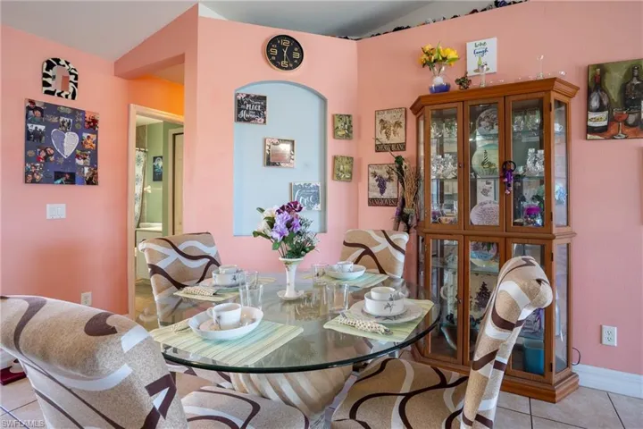 Dining space with vaulted ceiling and light tile patterned floors