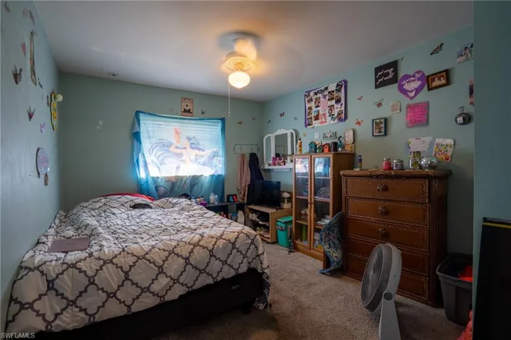 Carpeted bedroom featuring a ceiling fan