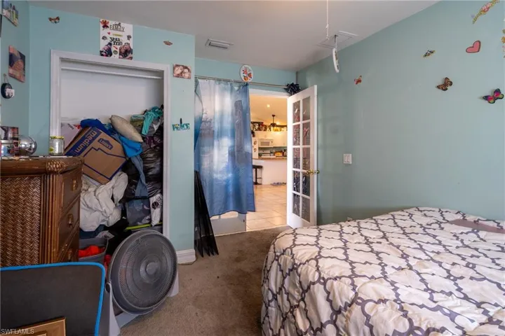 Bedroom featuring carpet flooring, visible vents, and tile patterned floors