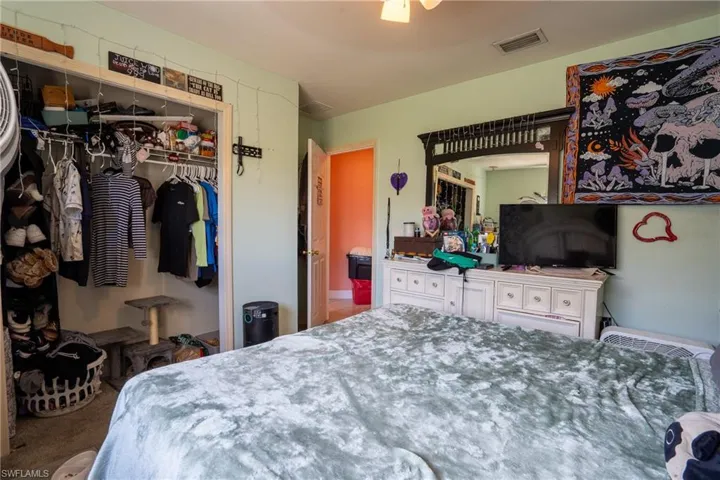 Carpeted bedroom featuring a closet and visible vents