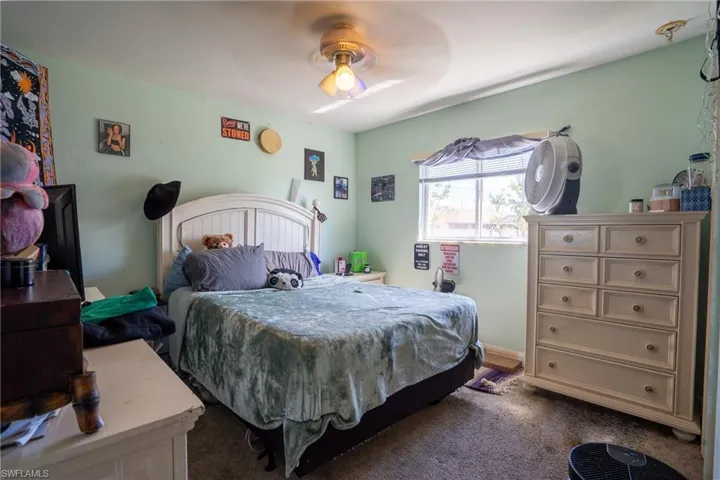 Bedroom featuring a ceiling fan and dark colored carpet
