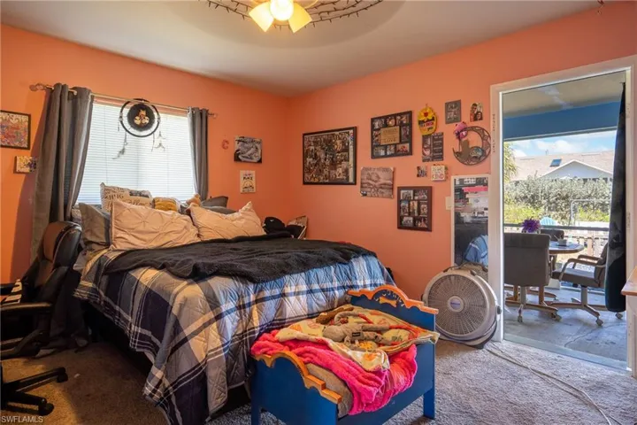 Carpeted bedroom with a ceiling fan, access to outside, and multiple windows