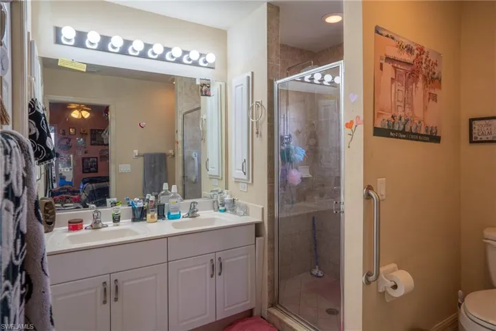 Ensuite bathroom with a stall shower, a sink, ensuite bath, and toilet