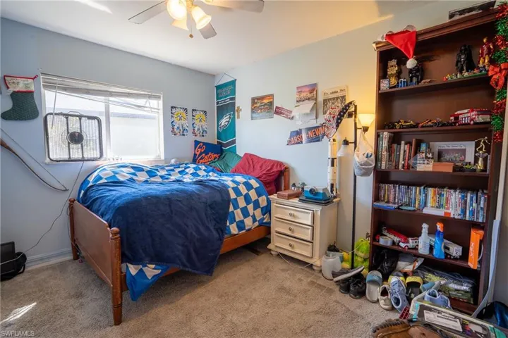 Carpeted bedroom featuring ceiling fan