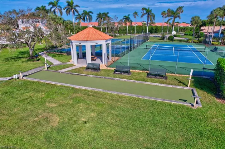 View of tennis court featuring a yard
