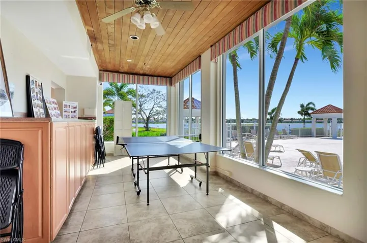 Recreation room featuring light tile patterned flooring, ceiling fan, and wood ceiling