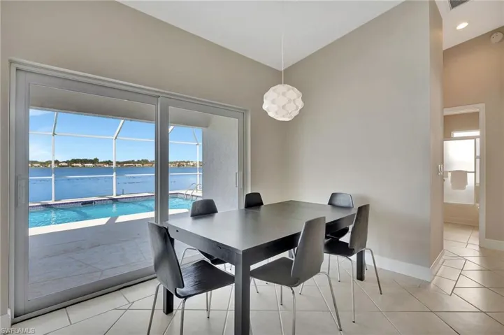 Tiled dining space featuring plenty of natural light and a water view