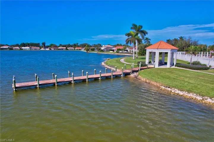 View of dock with a gazebo, a water view, and a lawn