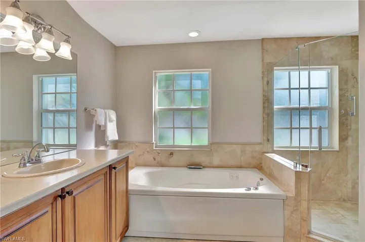 Bathroom featuring vanity and independent shower and bath