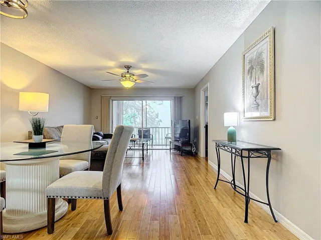 Dining room with ceiling fan, light hardwood / wood-style flooring, and a textured ceiling