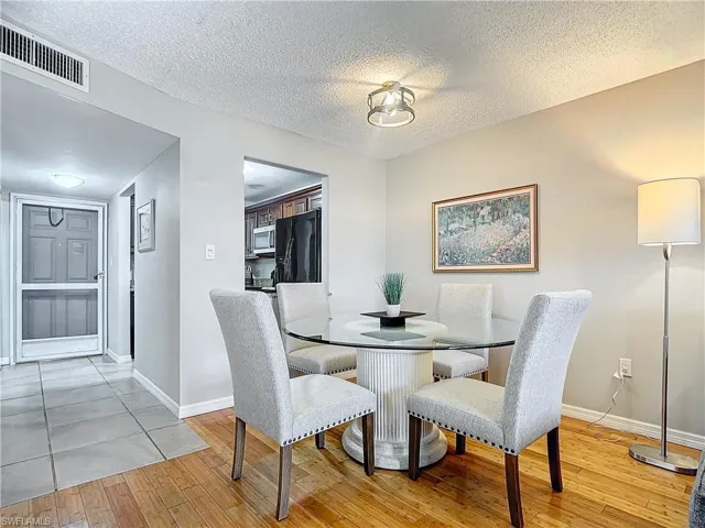 Dining room featuring a textured ceiling and light hardwood / wood-style floors