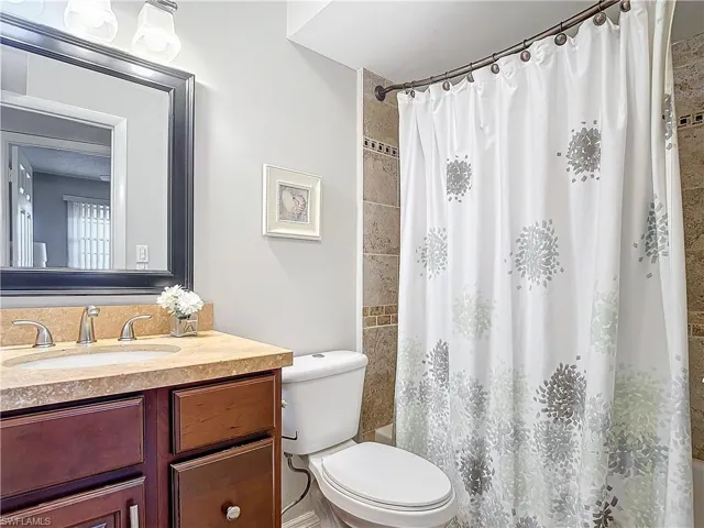 Full bathroom with shower / bath combination with curtain, vanity, and toilet