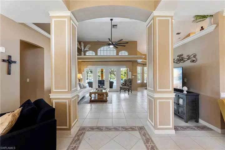 Entrance foyer with french doors, crown molding, light tile patterned floors, and ceiling fan