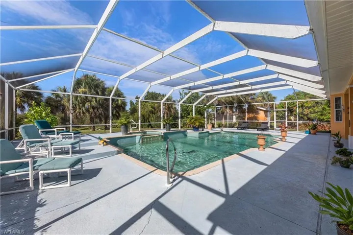 View of pool with a patio and glass enclosure