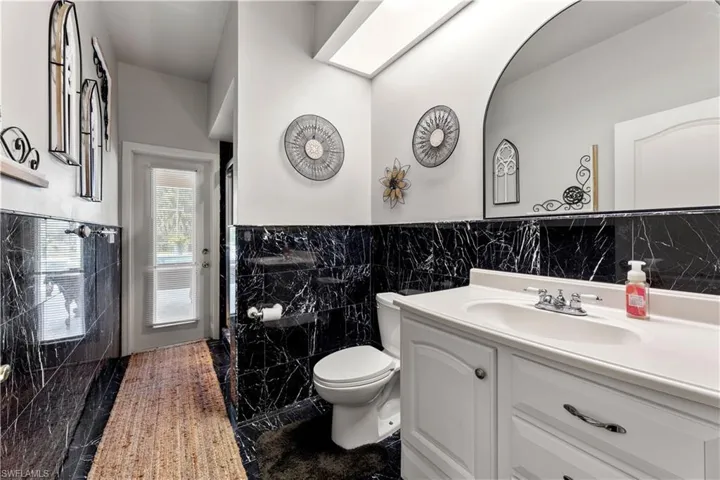 Bathroom featuring vanity, toilet, tile patterned flooring, and tile walls