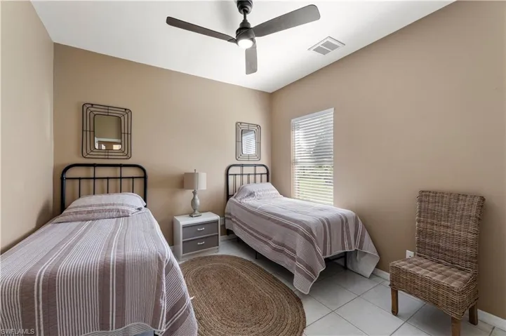 Bedroom with light tile patterned floors and ceiling fan