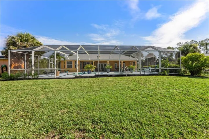 View of yard featuring a patio and glass enclosure