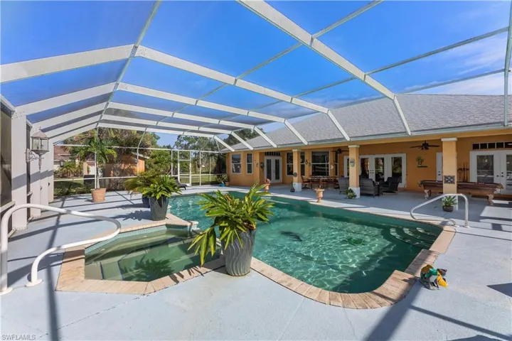 View of pool featuring a patio area, ceiling fan, outdoor lounge area, an in ground hot tub, and a lanai