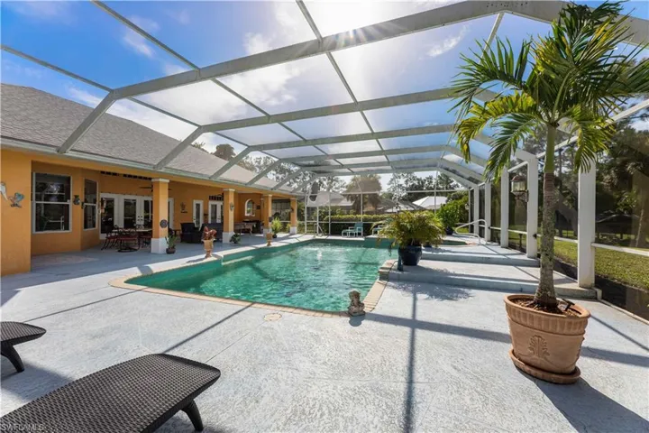 View of swimming pool featuring a patio area, a lanai, and ceiling fan