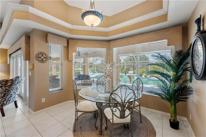 Tiled dining area featuring a tray ceiling